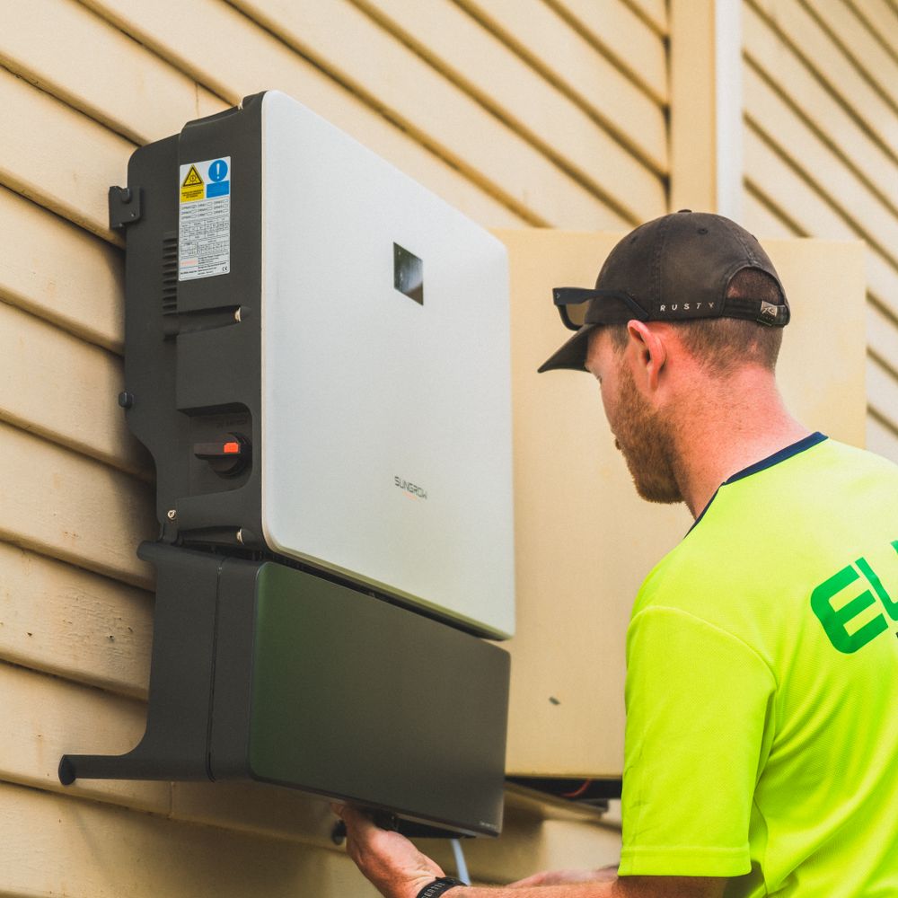Dış cephede inverter bağlantıları üzerinde çalışan teknisyen