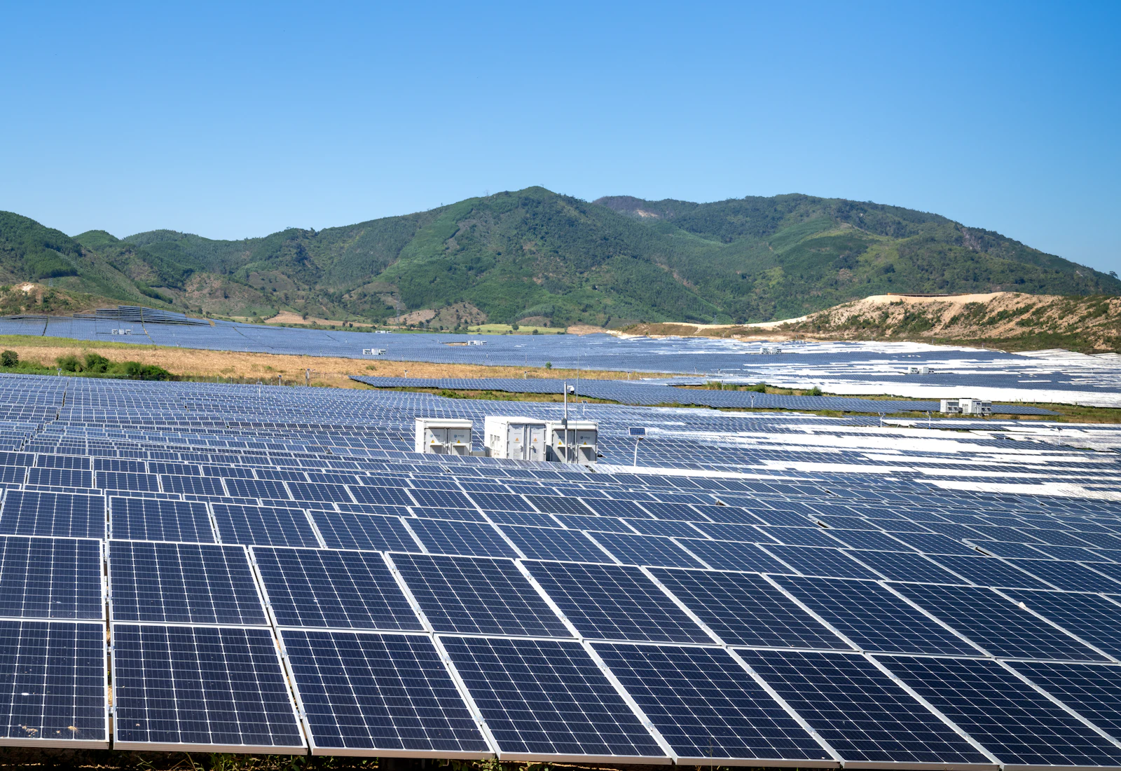 Dağların eteklerinde uzanan güneş enerjisi panelleri